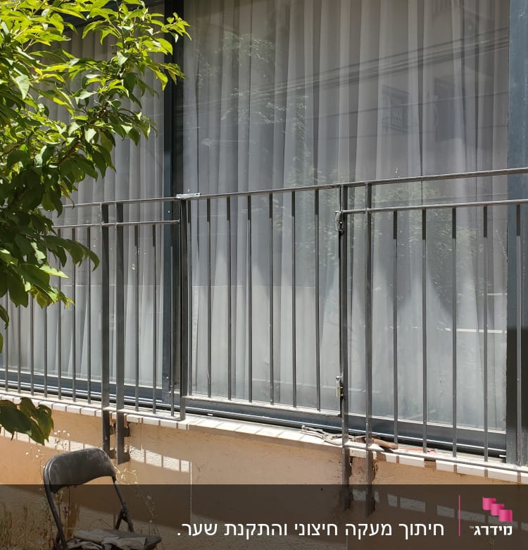 חלון גדול עם מסגרת מתכת וסורגים